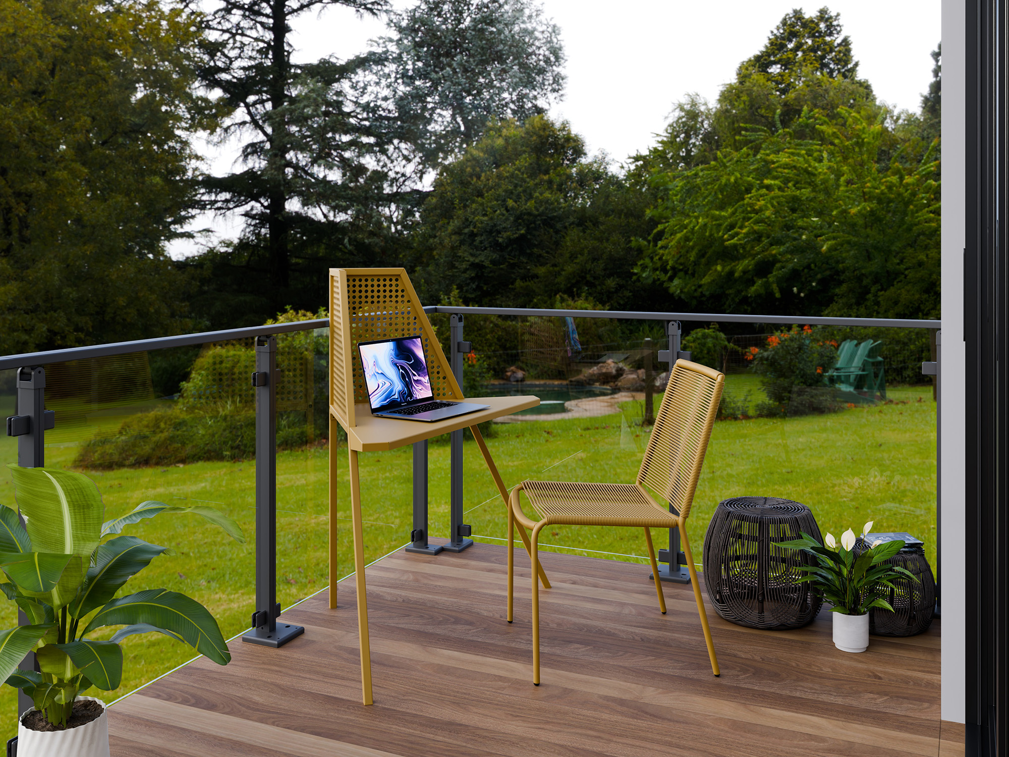 Ein moderner Balkonschreibtisch aus senfgelbem Metall mit perforierter Rückenlehne und einem passenden geflochtenen Stuhl auf einer Holzterrasse. Auf dem Schreibtisch steht ein Laptop, umgeben von Topfpflanzen und einem Beistelltisch aus dunklem Korb